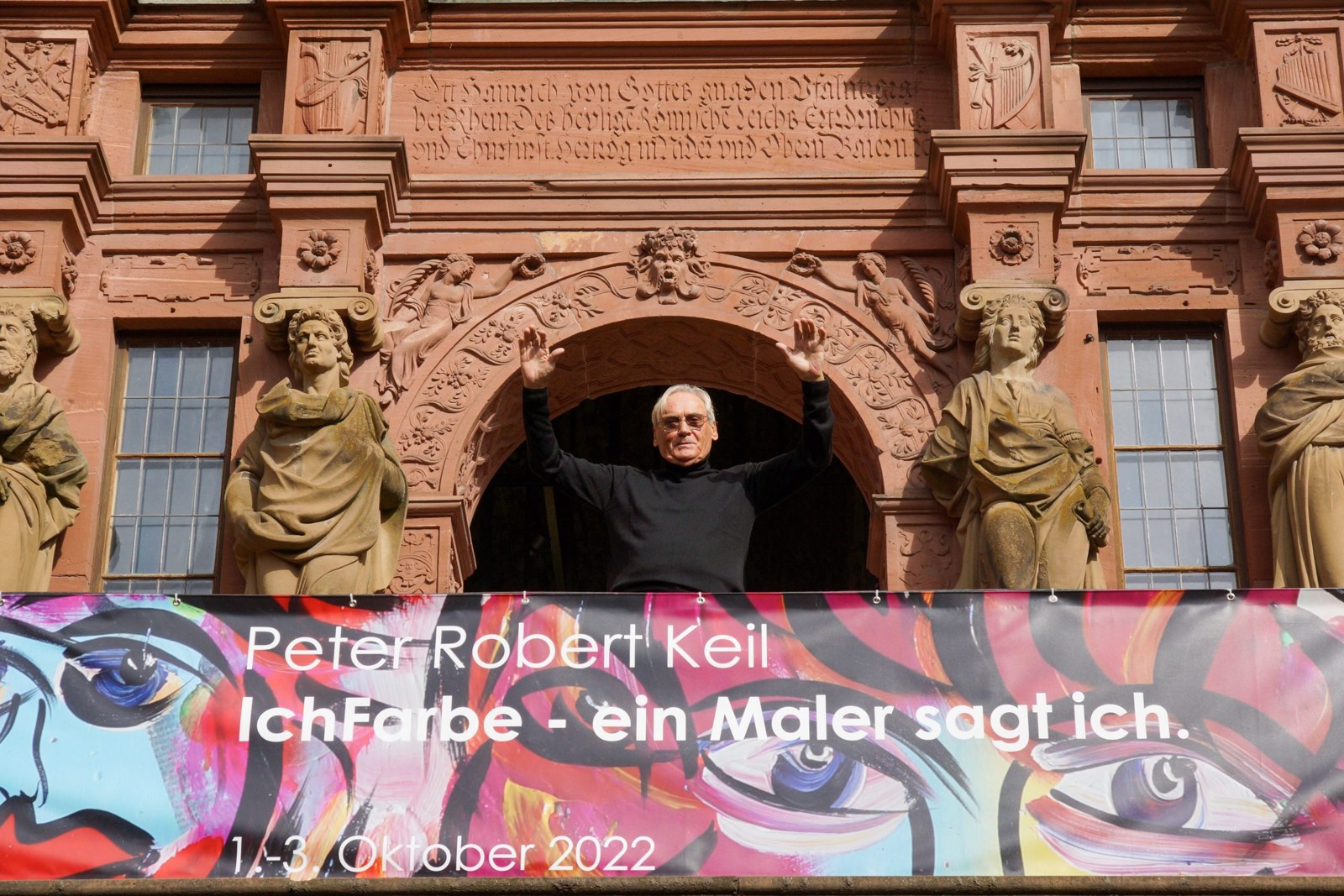 Peter Robert Keil at Heidelberg Castle with the IchFarbe exhibition banner, 2022.